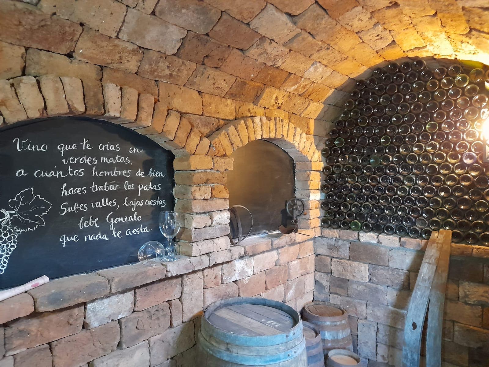 Bóveda de ladrillo arenisca del lagar con barriles y botellas apiladas en arco